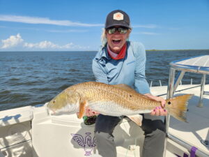 Angler holding a redfish caught on a Water First fly rod